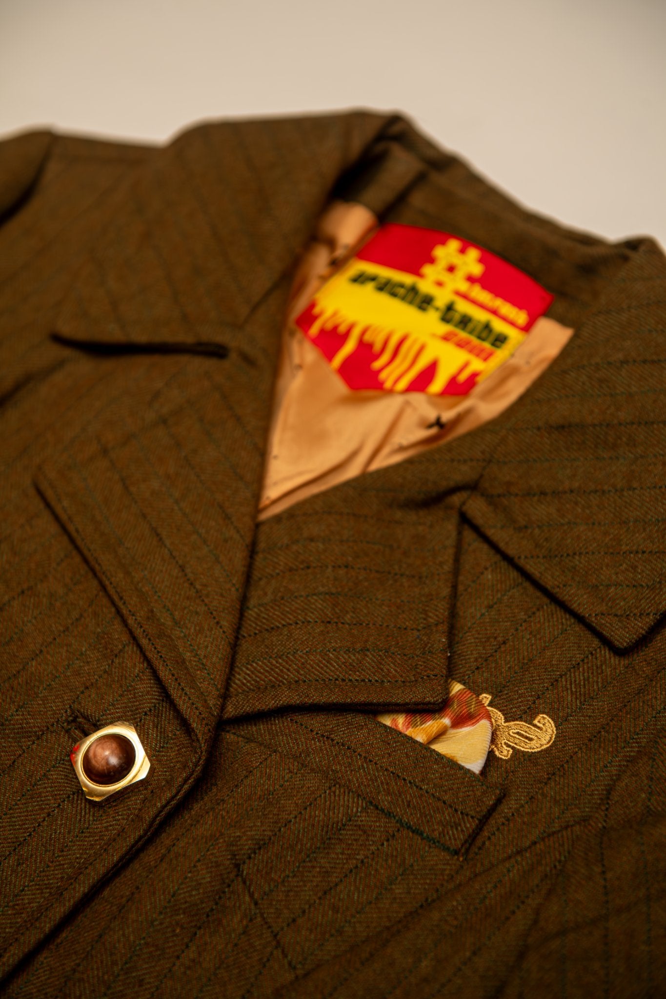 Brown herringbone tailored blazer with gold Apache embroidery detail, featuring peach lining and Apache Tribe Belfast red label