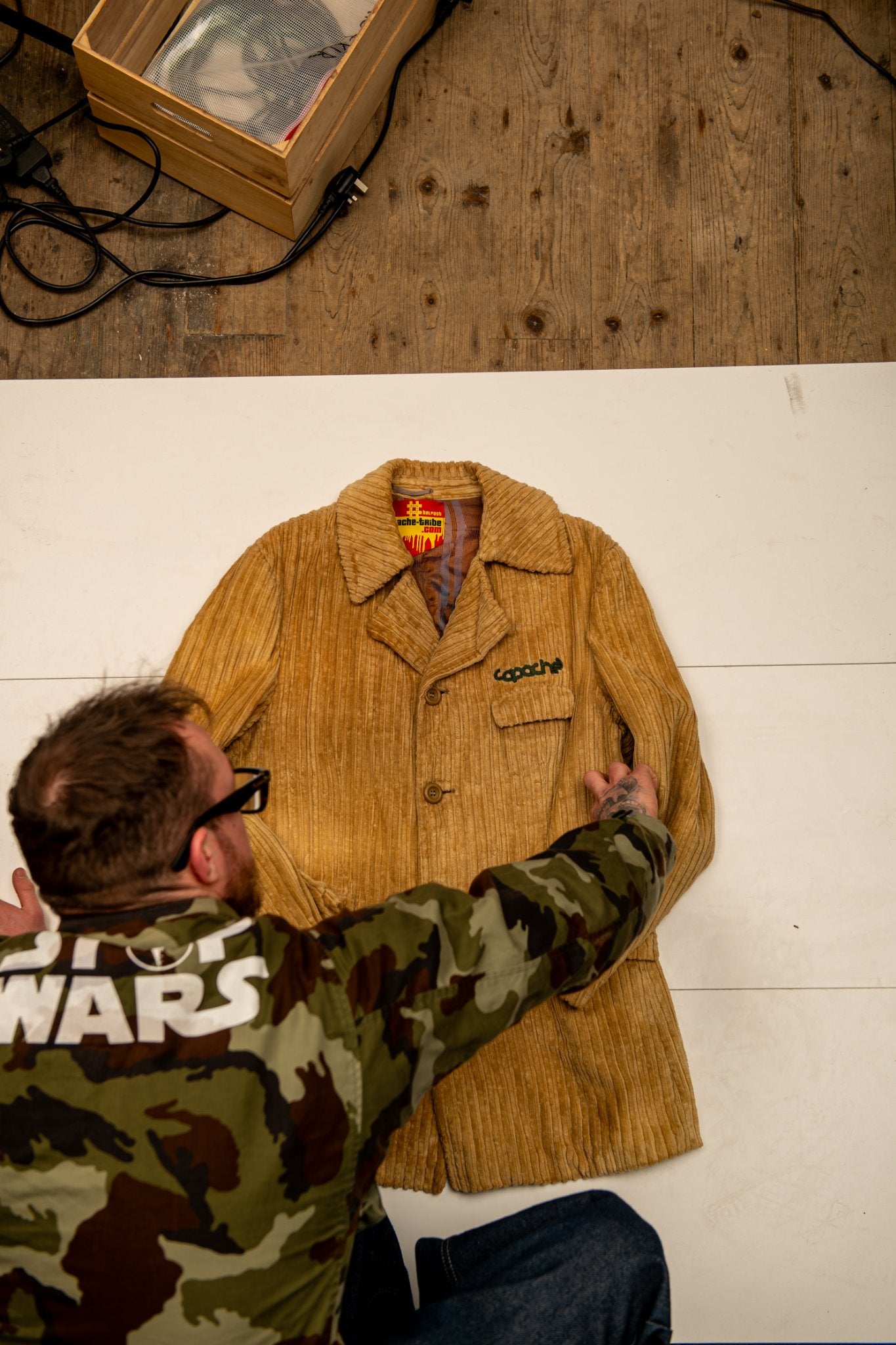 Tan corduroy Apache Cord Blazer with wide wale texture and embroidered Apache logo on chest, styled flat lay on white background
