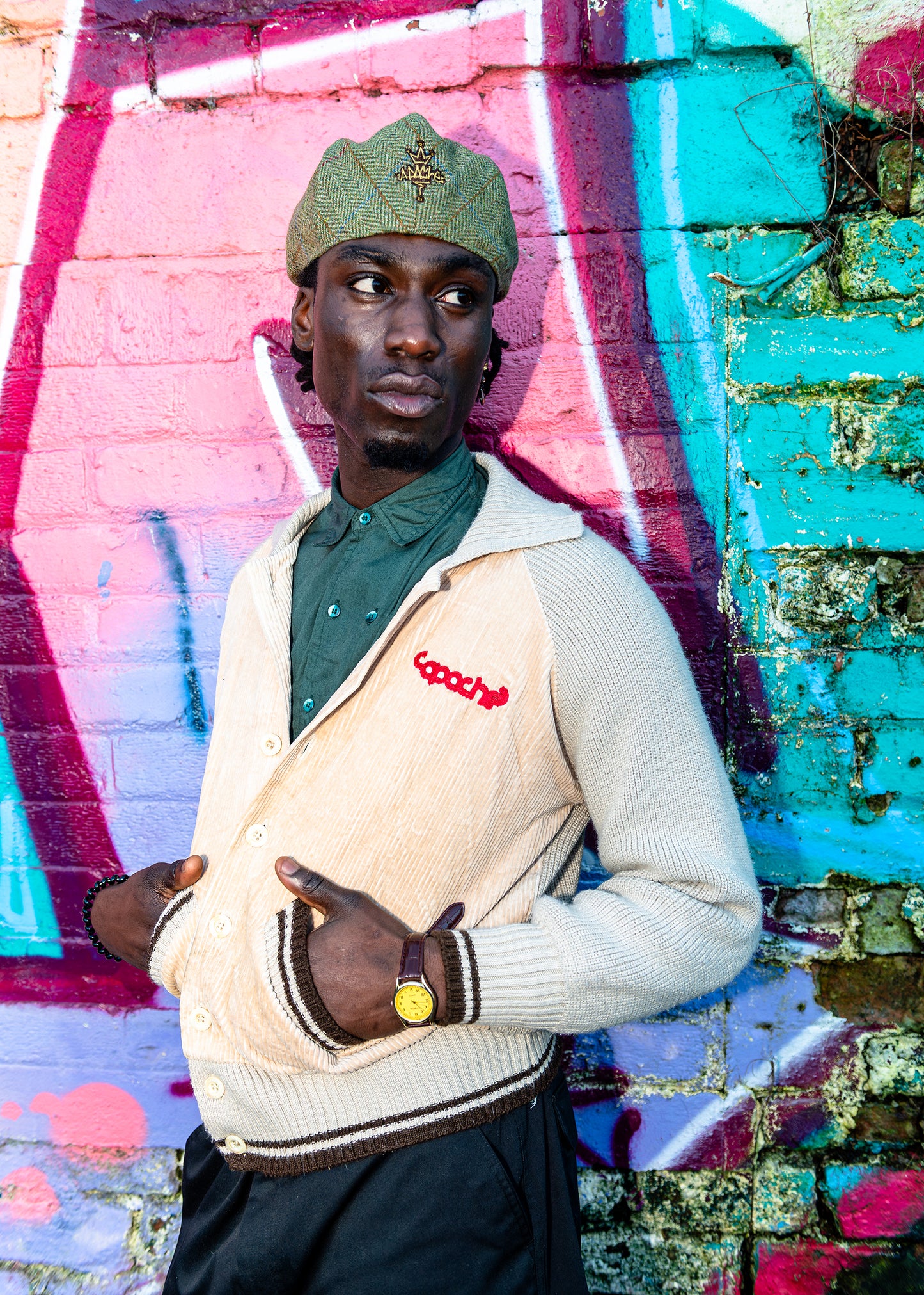 Apache Men's Cardigan in cream corduroy with knit sleeves, brown striped trim, and red Capache logo embroidery on chest