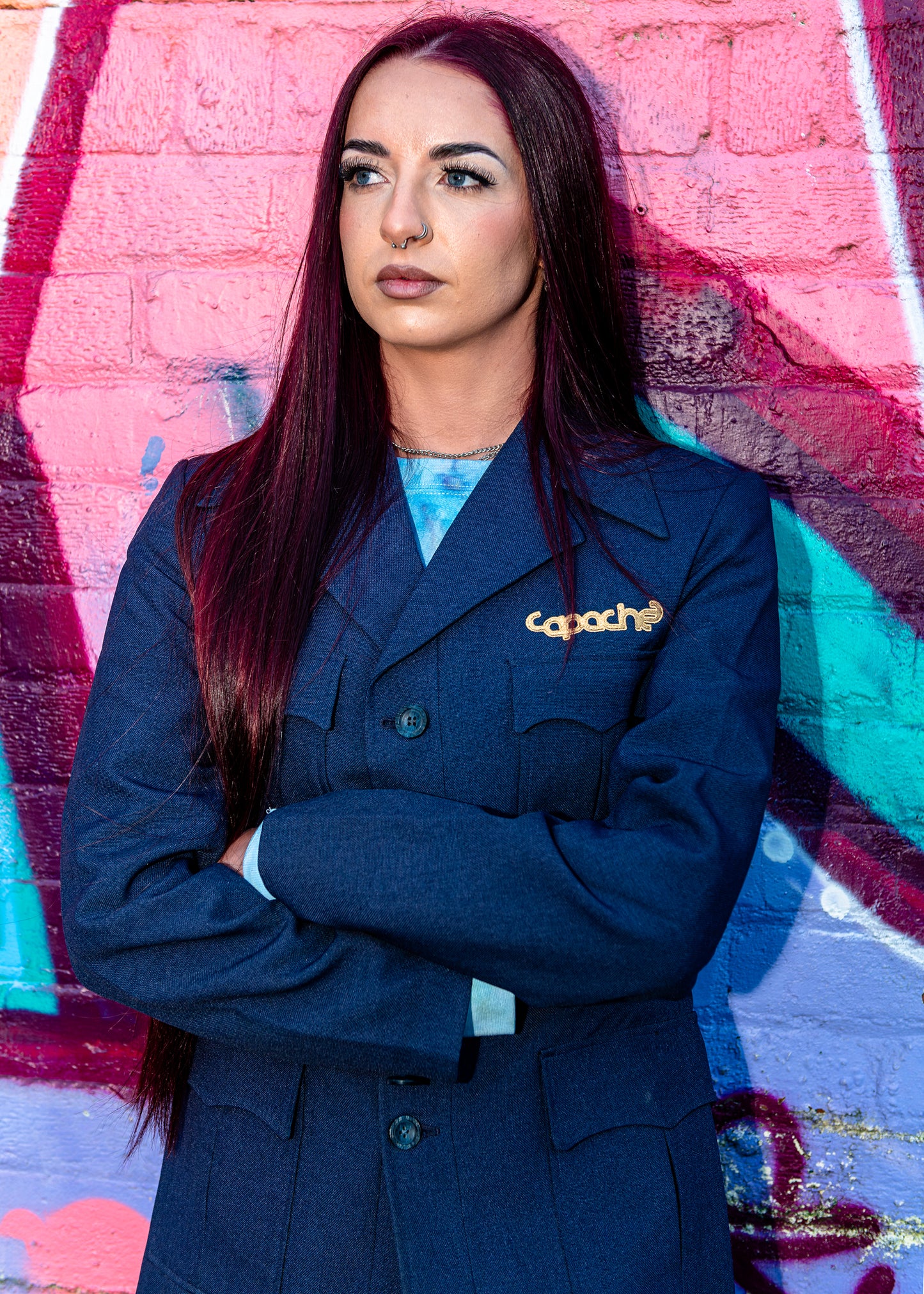 Woman wearing Blue Tailored Blazer with gold Apache logo pin, navy structured jacket with double-breasted design, streetwear styling