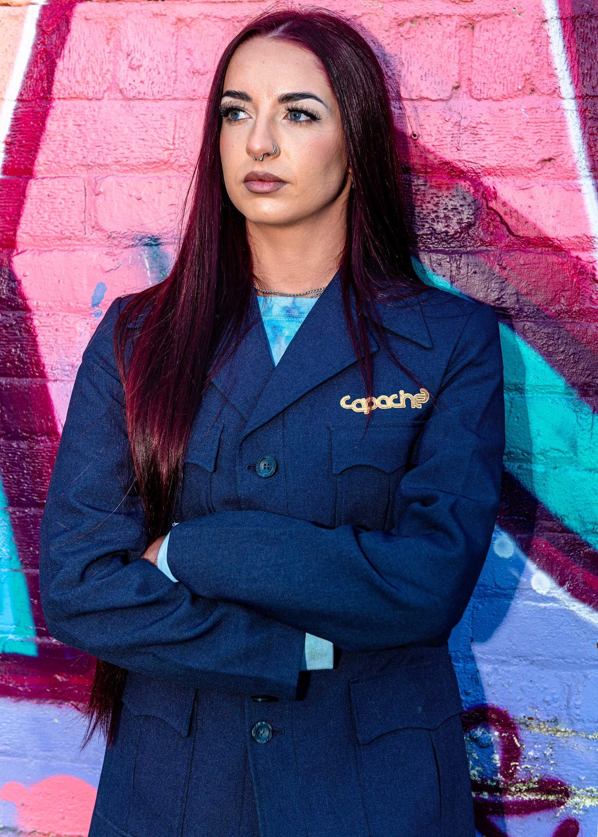 Woman wearing Blue Tailored Blazer with gold Apache logo pin, navy structured jacket with double-breasted design, streetwear styling
